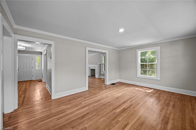 unfurnished room with baseboards, light wood-style floors, ornamental molding, a fireplace, and recessed lighting