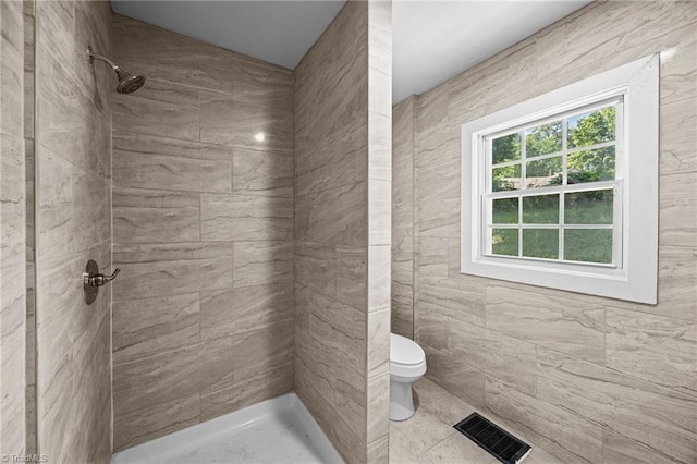 full bathroom featuring toilet and tiled shower