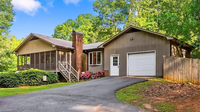 213 Byerly Dr, Thomasville, NC 27360 - view of front facade featuring a sunroom, an attached garage, a chimney, and driveway