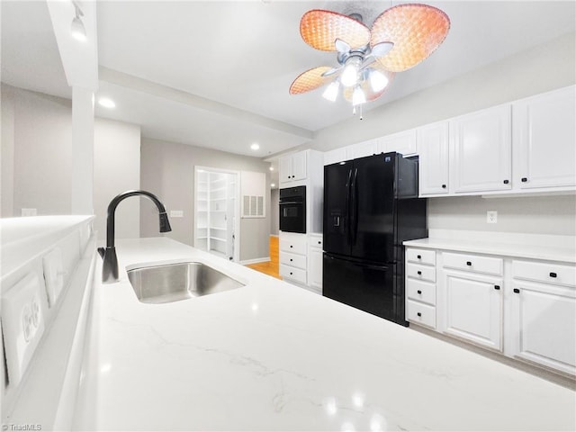 kitchen featuring black appliances, pendant lighting, white cabinetry, and sink