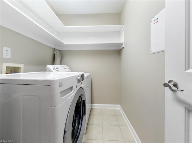 laundry room with washer and clothes dryer and light tile patterned floors