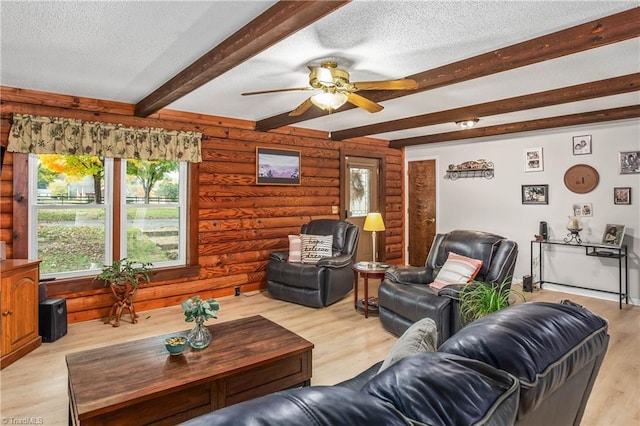 living room with light wood-type flooring, a textured ceiling, ceiling fan, and beam ceiling