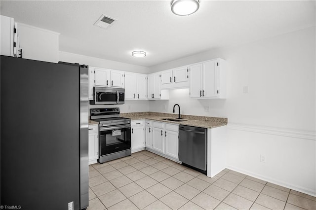 3114 Rockingham Rd, High Point, NC 27265 - kitchen with stainless steel appliances, white cabinets, light tile patterned floors, and light stone counters