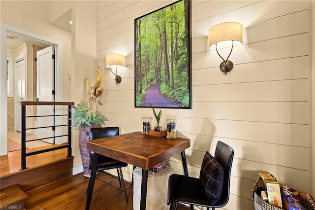 office area with dark hardwood / wood-style floors and wooden walls