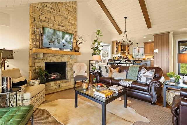 living room with high vaulted ceiling, beamed ceiling, a chandelier, a fireplace, and wood ceiling