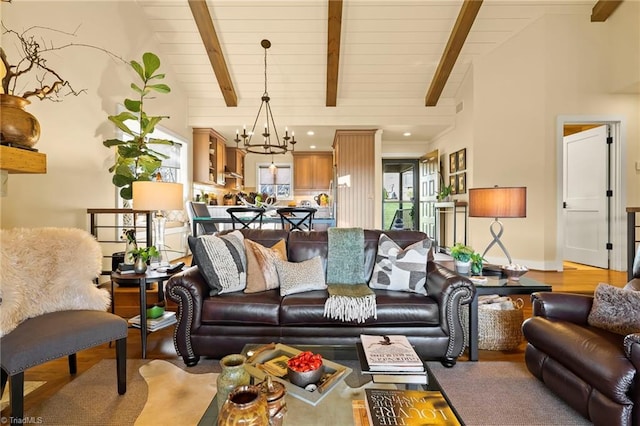 living room featuring beamed ceiling, high vaulted ceiling, a notable chandelier, and light wood-type flooring