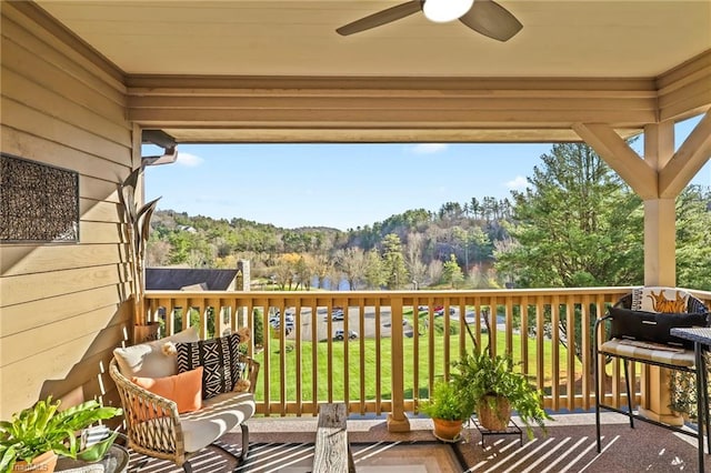 wooden terrace featuring ceiling fan and a yard