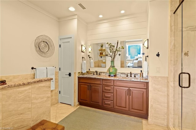 bathroom with vanity, a shower with door, and ornamental molding