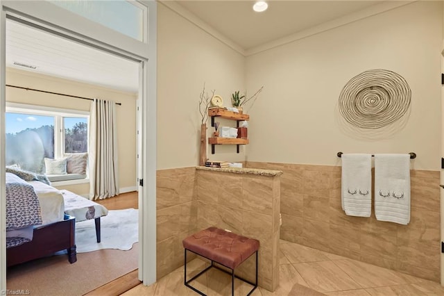 bathroom featuring hardwood / wood-style floors, ornamental molding, and tile walls