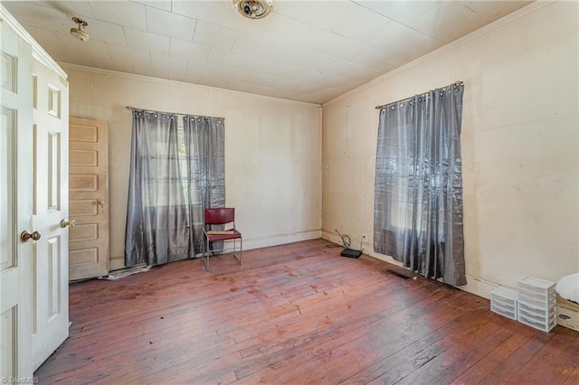 spare room featuring hardwood / wood-style flooring and ornamental molding