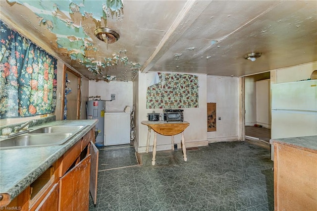 kitchen with sink, electric water heater, white fridge, and washer / clothes dryer