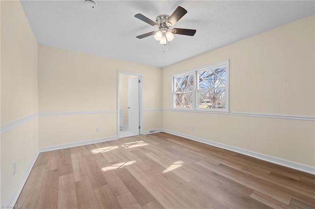 spare room featuring a textured ceiling, light hardwood / wood-style floors, and ceiling fan