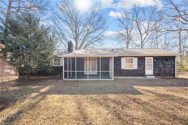 back of house featuring a lawn and a sunroom