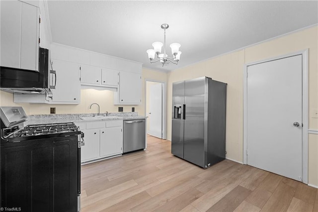 kitchen featuring pendant lighting, stainless steel appliances, light hardwood / wood-style flooring, and white cabinets