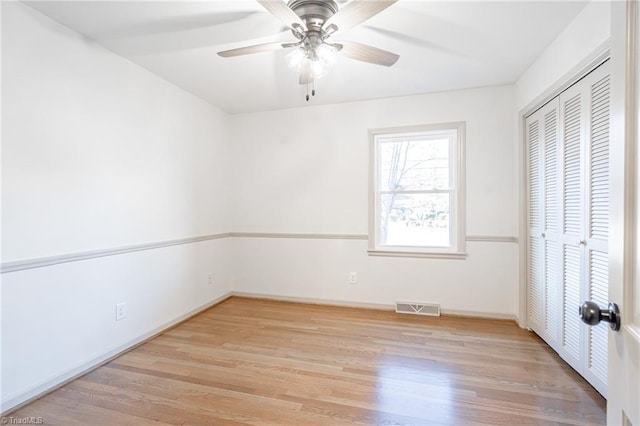 unfurnished bedroom with light wood-type flooring, a closet, and ceiling fan