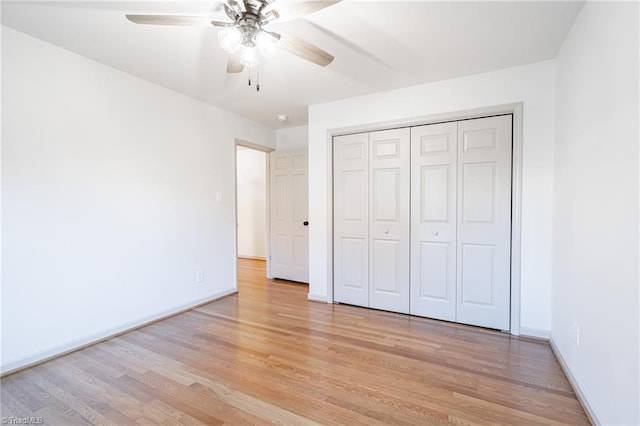 unfurnished bedroom featuring ceiling fan, light hardwood / wood-style flooring, and a closet