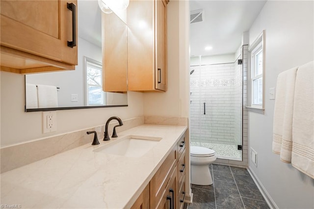 bathroom featuring toilet, vanity, an enclosed shower, and a healthy amount of sunlight