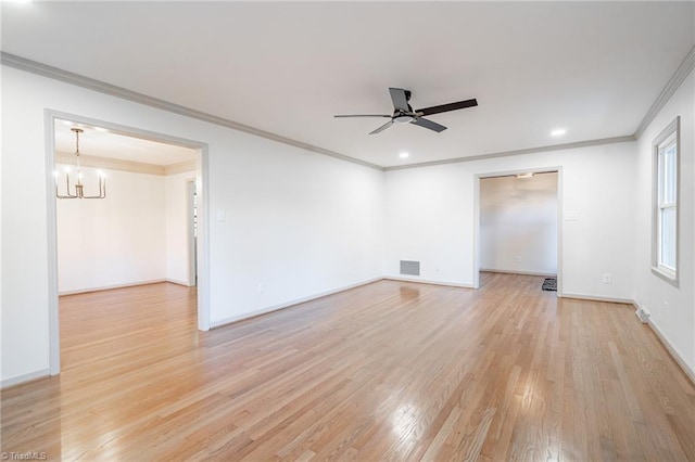 spare room featuring light wood-type flooring, ornamental molding, and ceiling fan with notable chandelier