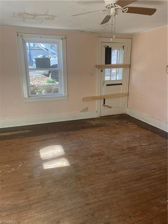 unfurnished room with ceiling fan and dark hardwood / wood-style flooring