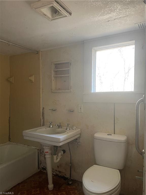 bathroom featuring toilet and a tub