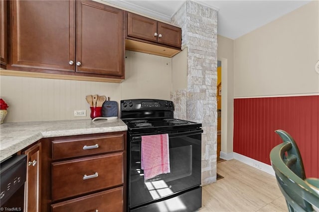 kitchen with black appliances, light countertops, a wainscoted wall, and ornate columns