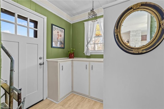 foyer featuring ornamental molding and light wood-style flooring