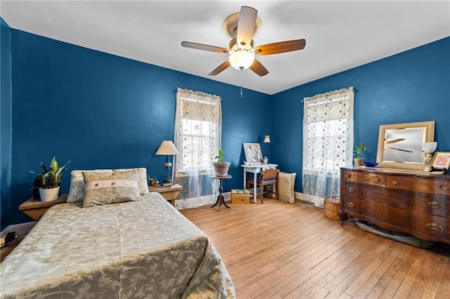 bedroom featuring ceiling fan, baseboards, and hardwood / wood-style flooring