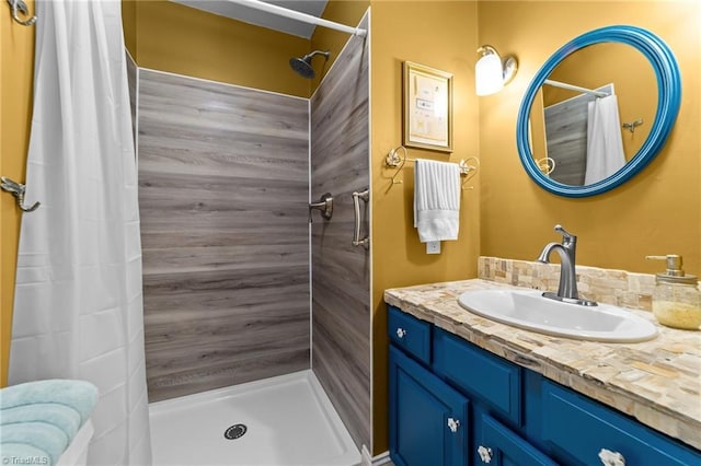 bathroom with a tile shower and vanity