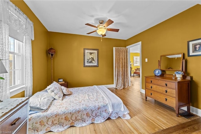 bedroom featuring a ceiling fan, baseboards, and wood finished floors