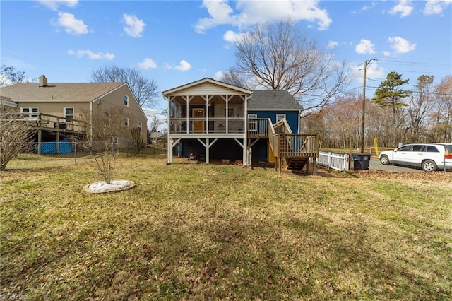 rear view of house with fence, a yard, a deck, and stairs