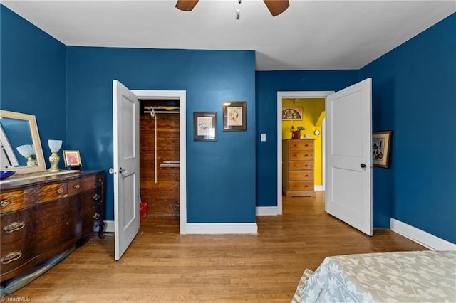 bedroom with ceiling fan, baseboards, and wood finished floors