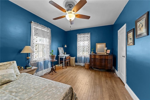 bedroom featuring a ceiling fan, hardwood / wood-style flooring, and baseboards