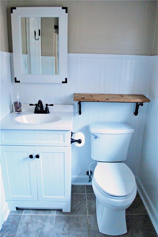 bathroom with vanity, tile patterned flooring, and toilet