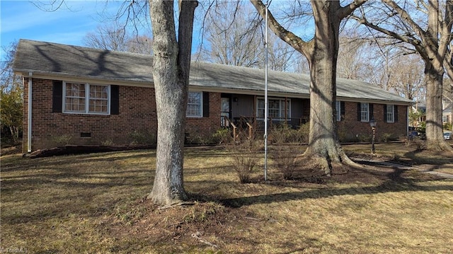 ranch-style home featuring covered porch and a front yard