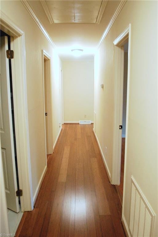 hallway with light wood-type flooring and ornamental molding