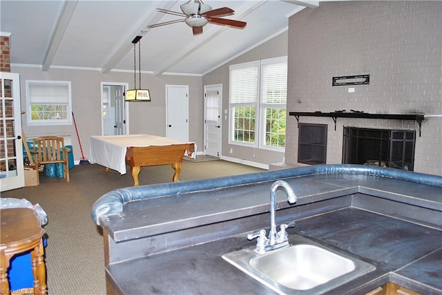 rec room with carpet flooring, lofted ceiling with beams, ceiling fan, a fireplace, and sink