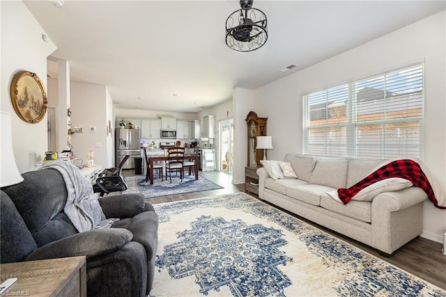 living area featuring light wood finished floors, visible vents, and baseboards