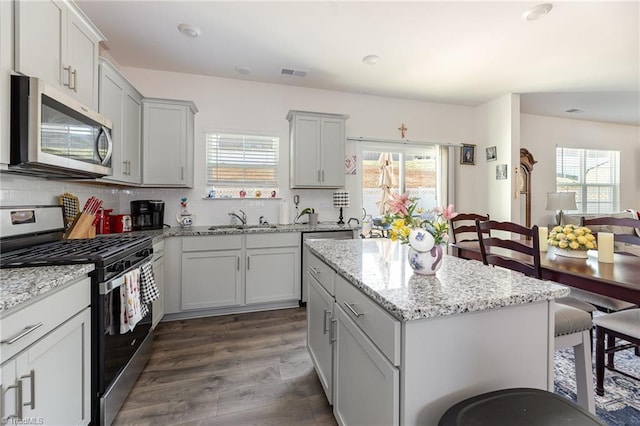 kitchen featuring backsplash, visible vents, appliances with stainless steel finishes, and a sink