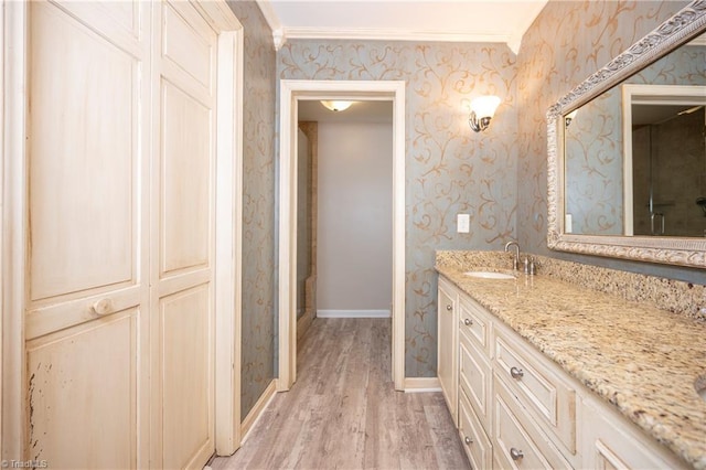 bathroom with vanity, hardwood / wood-style flooring, and crown molding