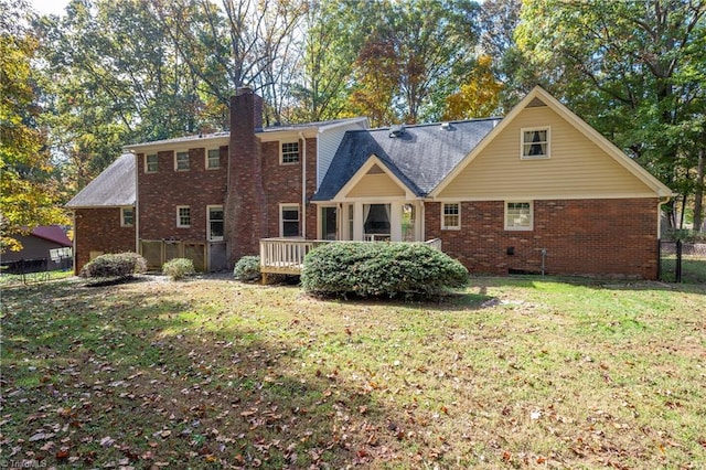 back of property with a wooden deck and a yard