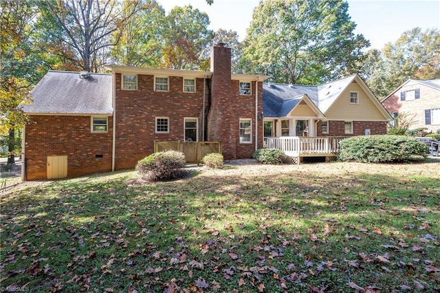 back of house featuring a wooden deck and a lawn