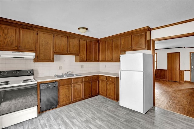 kitchen featuring light wood-type flooring, white appliances, decorative backsplash, and sink