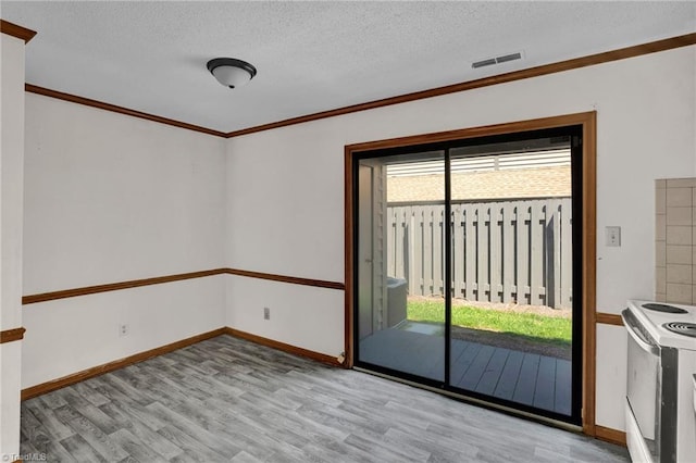 doorway to outside with a textured ceiling, light hardwood / wood-style flooring, and ornamental molding