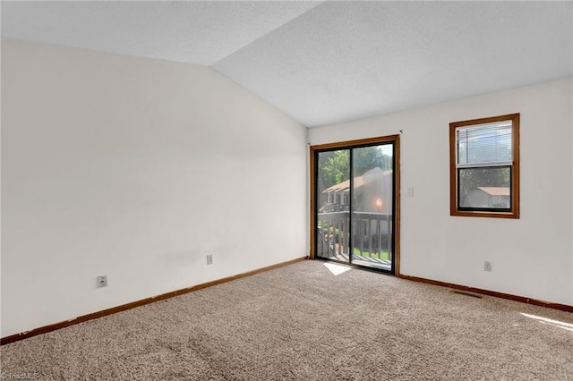 carpeted spare room with vaulted ceiling