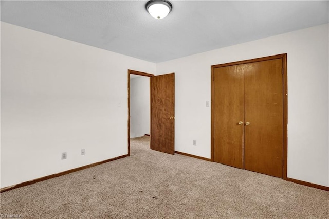 unfurnished bedroom featuring light carpet and a closet