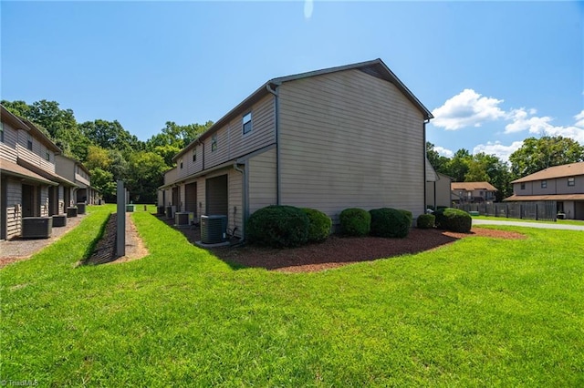 view of side of home featuring a lawn and central AC unit