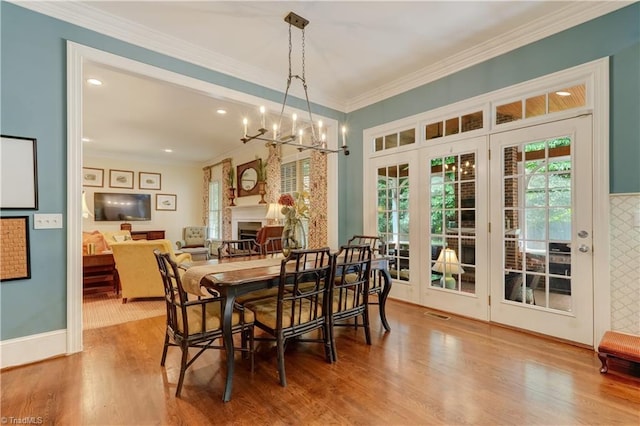 3612 Camden Falls Cir, Greensboro, NC 27410 - dining area featuring ornamental molding, a chandelier, wood finished floors, a fireplace, and recessed lighting