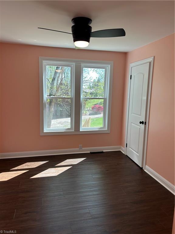 219 Highland Ave, Elkin, NC 28621 - empty room featuring plenty of natural light, baseboards, and dark wood-style flooring