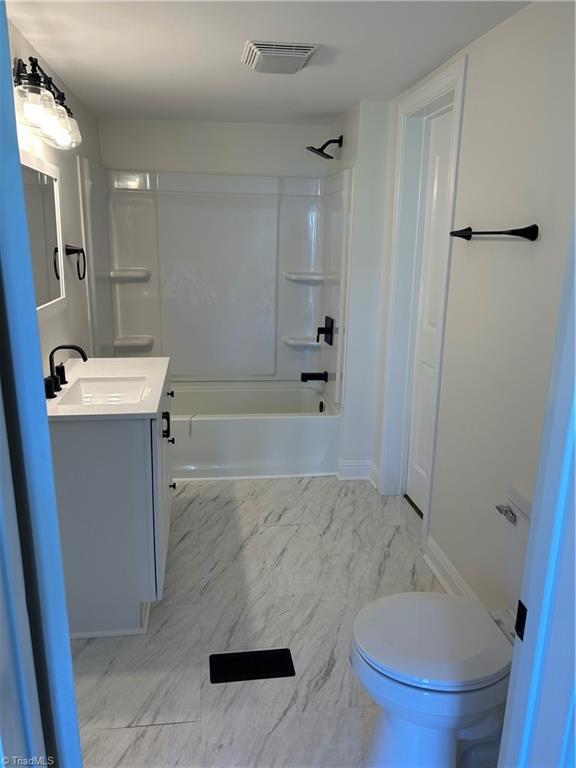 219 Highland Ave, Elkin, NC 28621 - full bath featuring vanity, toilet, bathtub / shower combination, baseboards, and marble look tile flooring