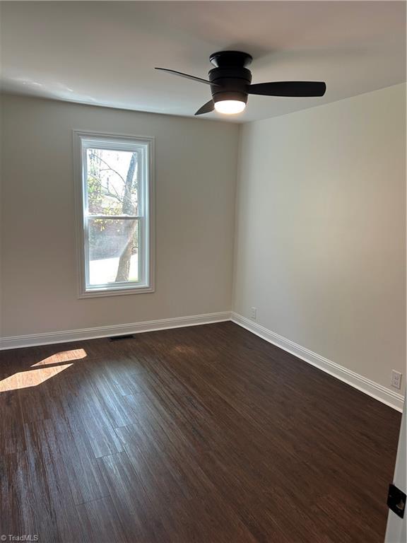 219 Highland Ave, Elkin, NC 28621 - spare room with dark wood-style flooring, baseboards, and a ceiling fan
